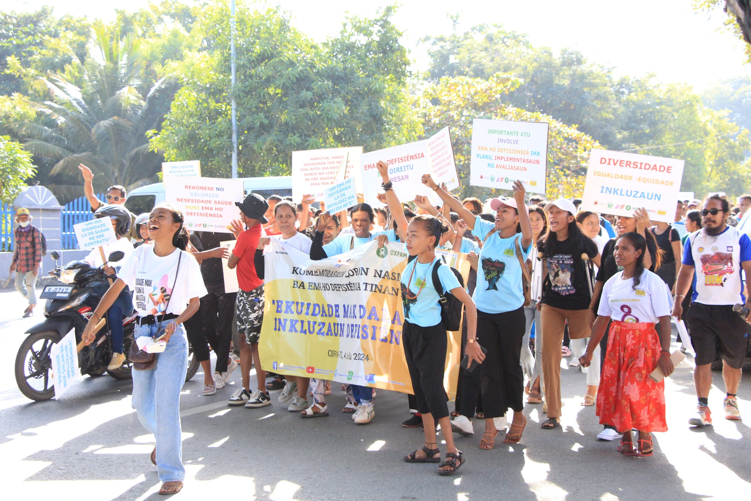 Carmelita Araujo (front left) leading a group of supporters in a march through Dili, Timor-Leste, in honor of the 2024 Day for People with Disabilities. The march advocates for increased rights for people with disabilities throughout Timor-Leste.